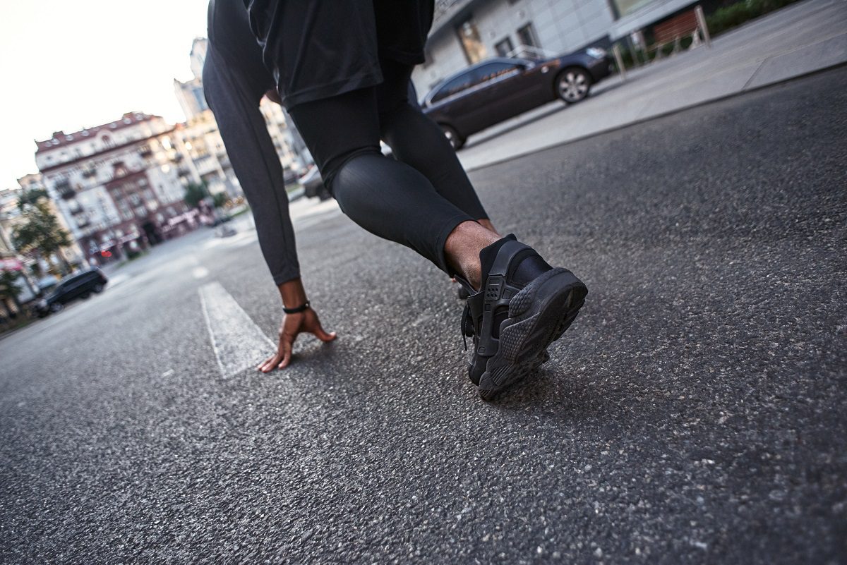 Ready to go Close-up photo of sportsman preparing for start in running position. Sport motivation concept. Cardio training. Morning workout.